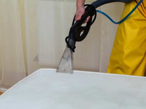 This is a photo of a man steam cleaning a dirty mattress works carried out by Rickmansworth Carpet Cleaning