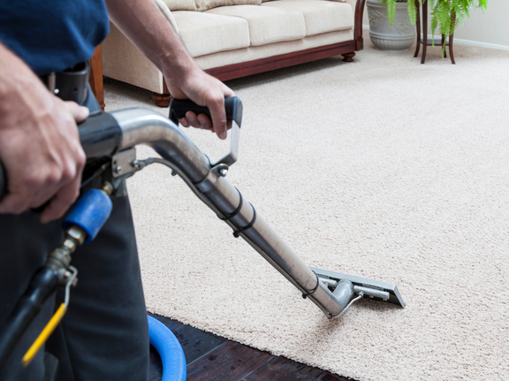 This is a photo of a man with a steam cleaner cleaning a cream carpet works carried out by Rickmansworth Carpet Cleaning